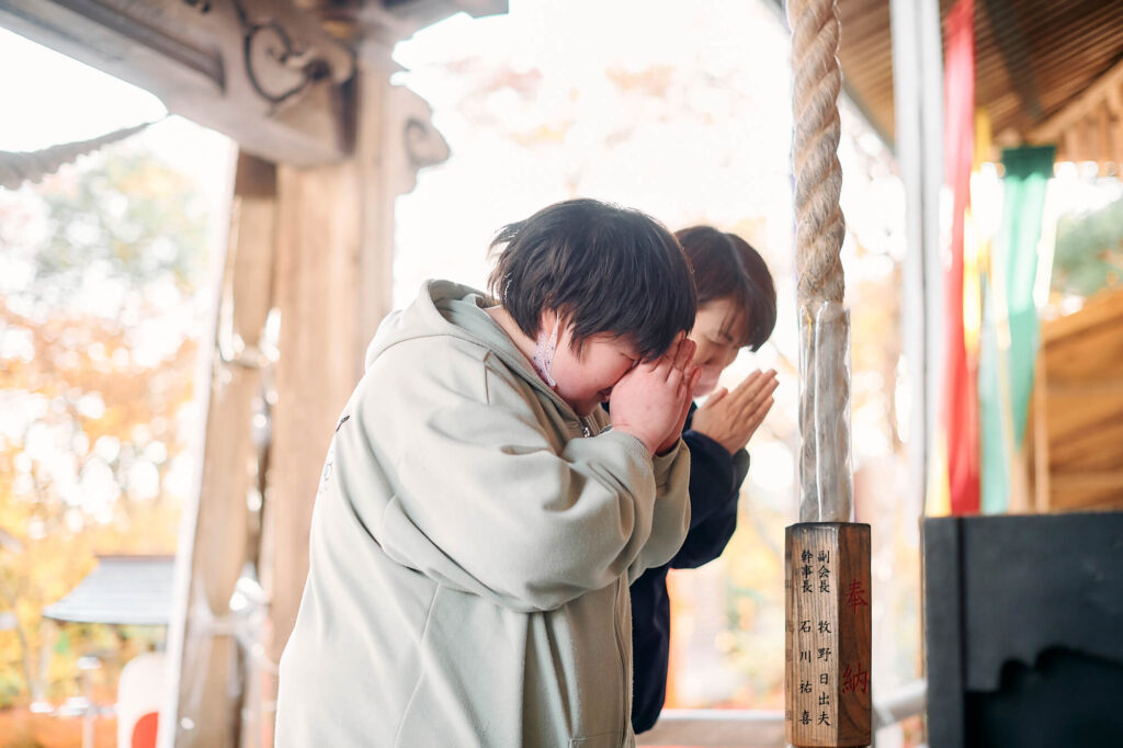 神社でお参りをする戸島さんと晶子さん