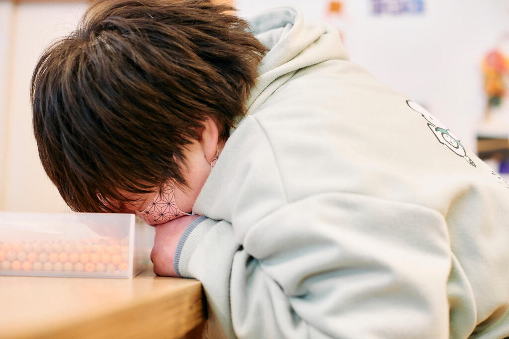 ビーズの箱を覗き込む晶子さん